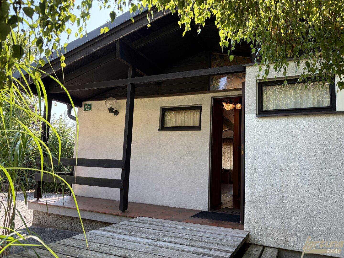 Eingangsbereich eines Hauses mit überdachtem Vorbau und Holzdetails.