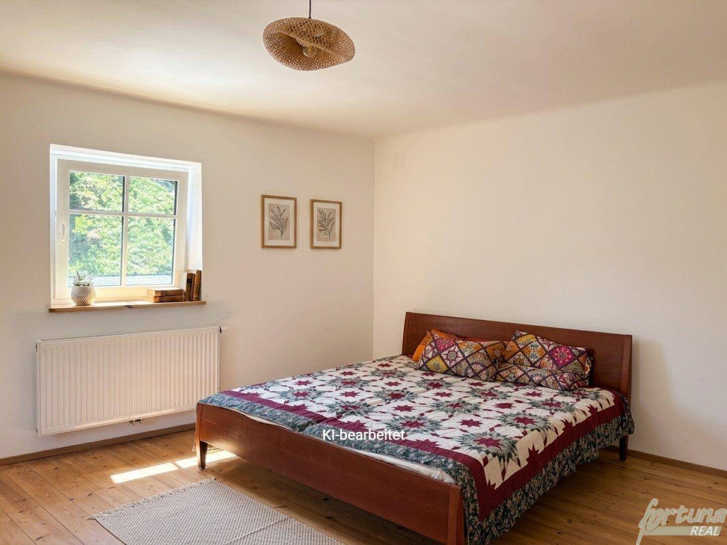 Schlafzimmer mit Holzbett, gemusterter Bettdecke, Holzdielenboden und Fenster.