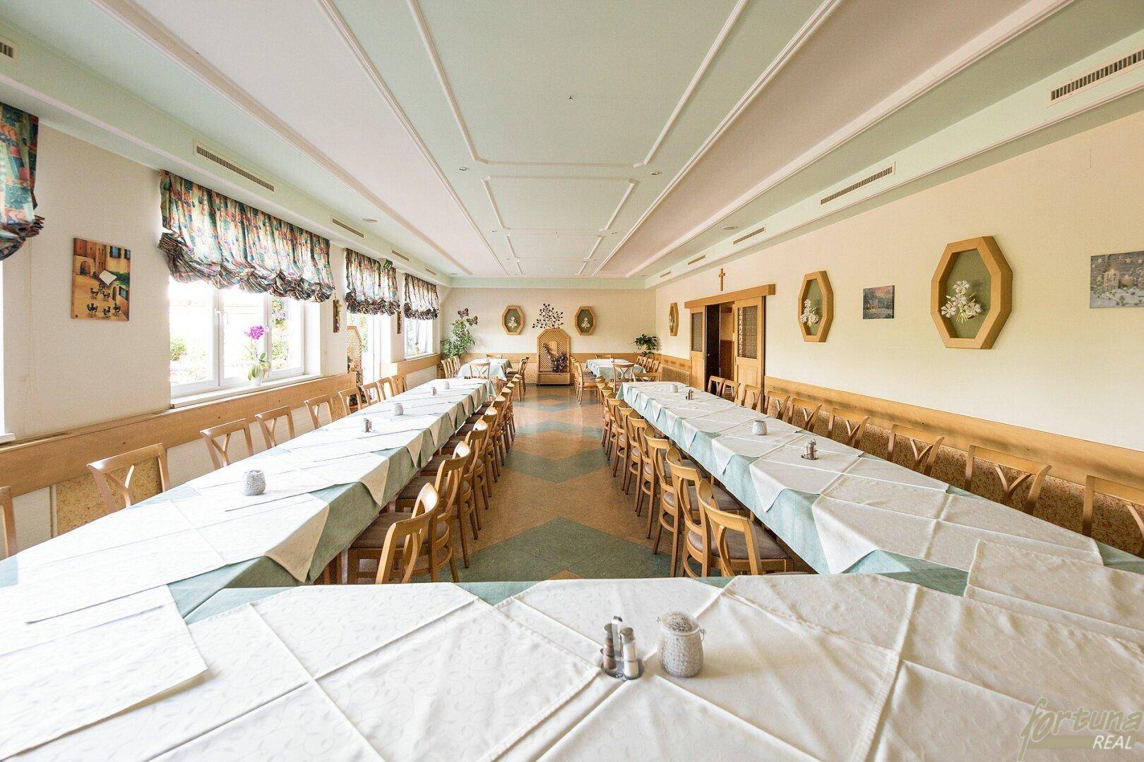Weitläufiger Speisesaal mit langen Tischreihen, bereit für größere Veranstaltungen.
