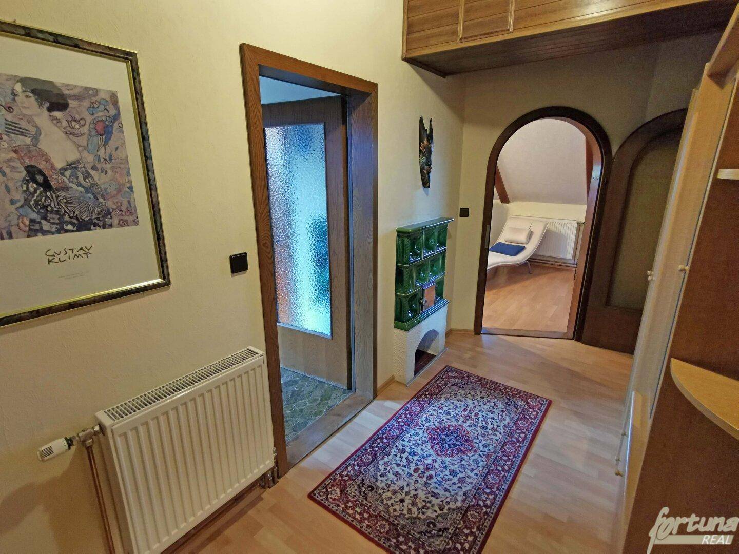 Flur im Dachgeschoss mit Holzboden, Heizkörper und Zugang zu weiteren Räumen.