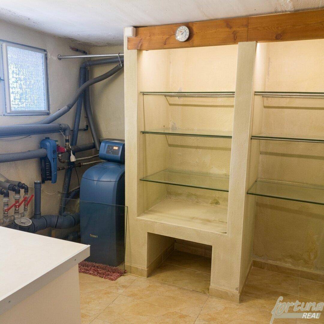 Hauswirtschaftsraum im Keller mit Wasserenthärtungsanlage und praktischen Regalen.