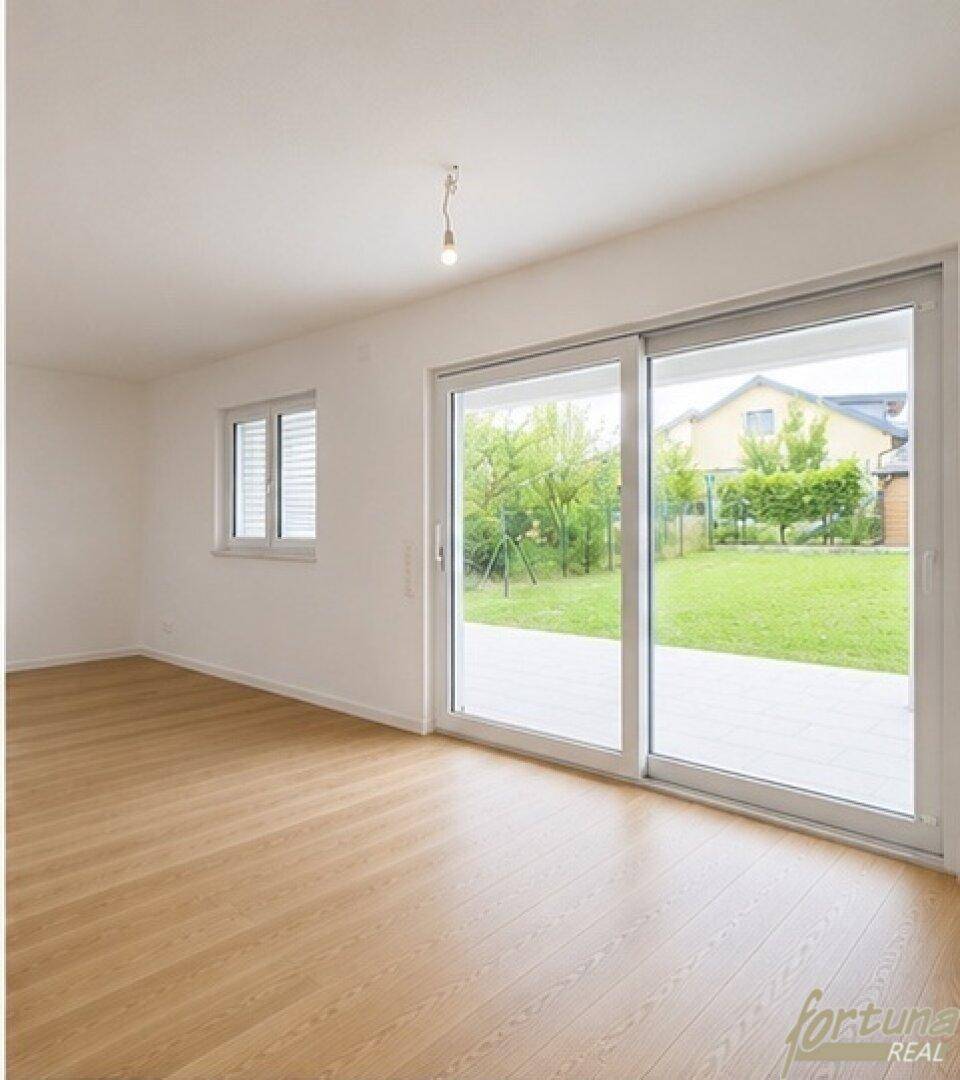 Helles Wohnzimmer mit hochwertigem Holzfußboden und großer Schiebetür zum Garten.