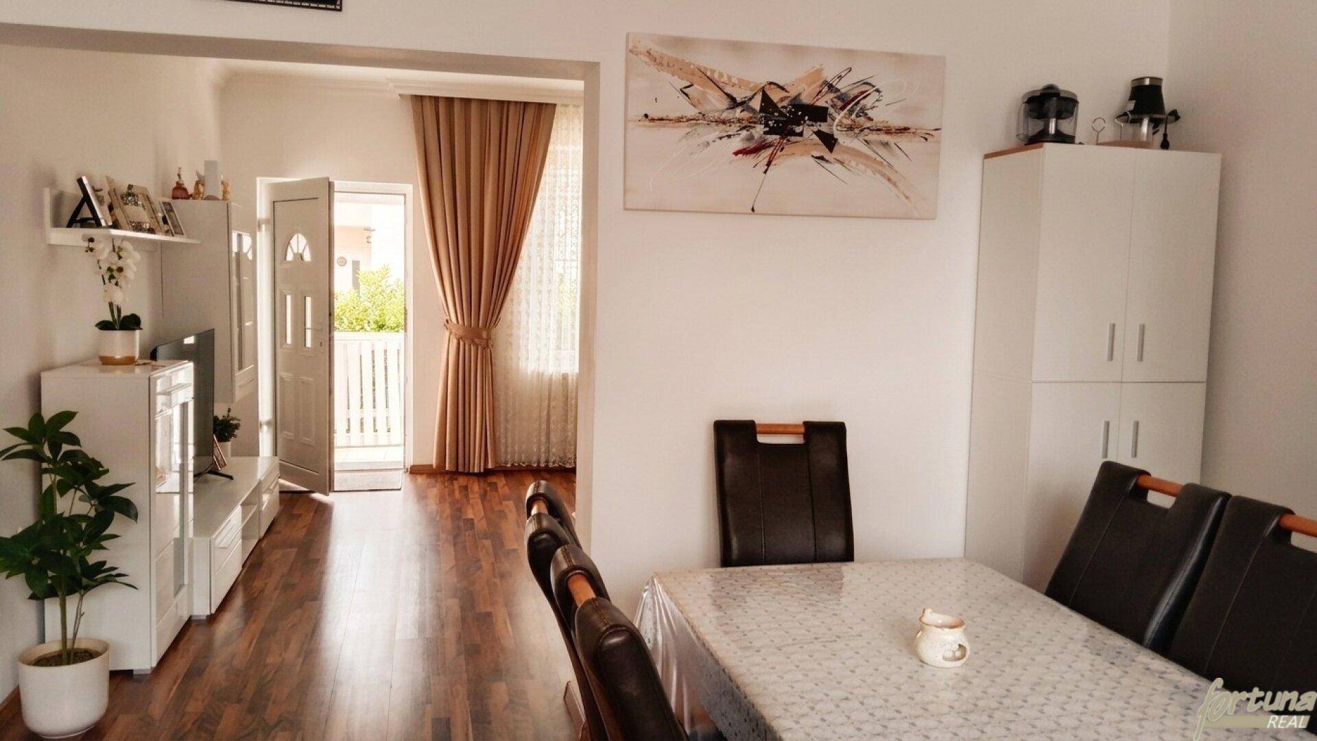 Essbereich mit Tisch und Stühlen, offen zum Wohnzimmer mit Zugang zu einem Balkon.