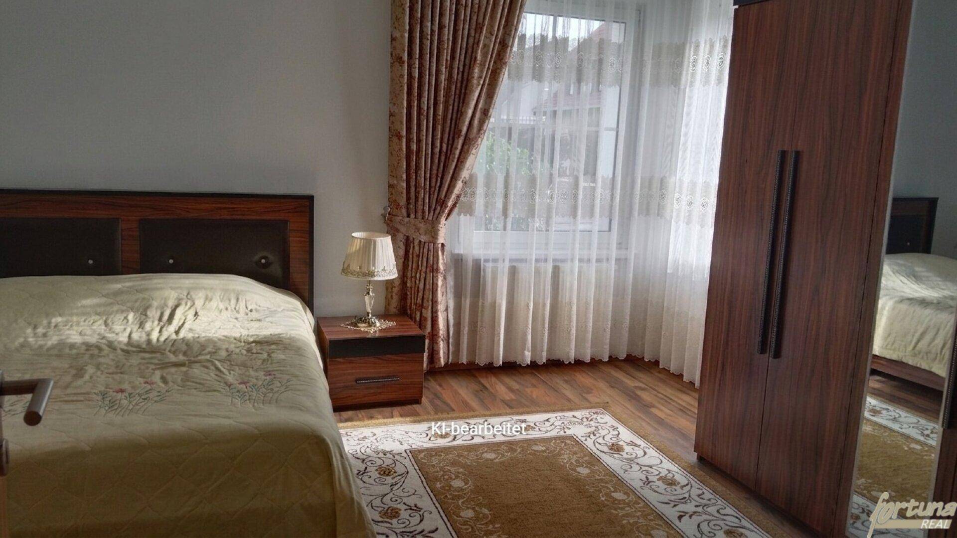 Schlafzimmer mit dunklem Holzbett, passendem Kleiderschrank und hellem Holzboden.
