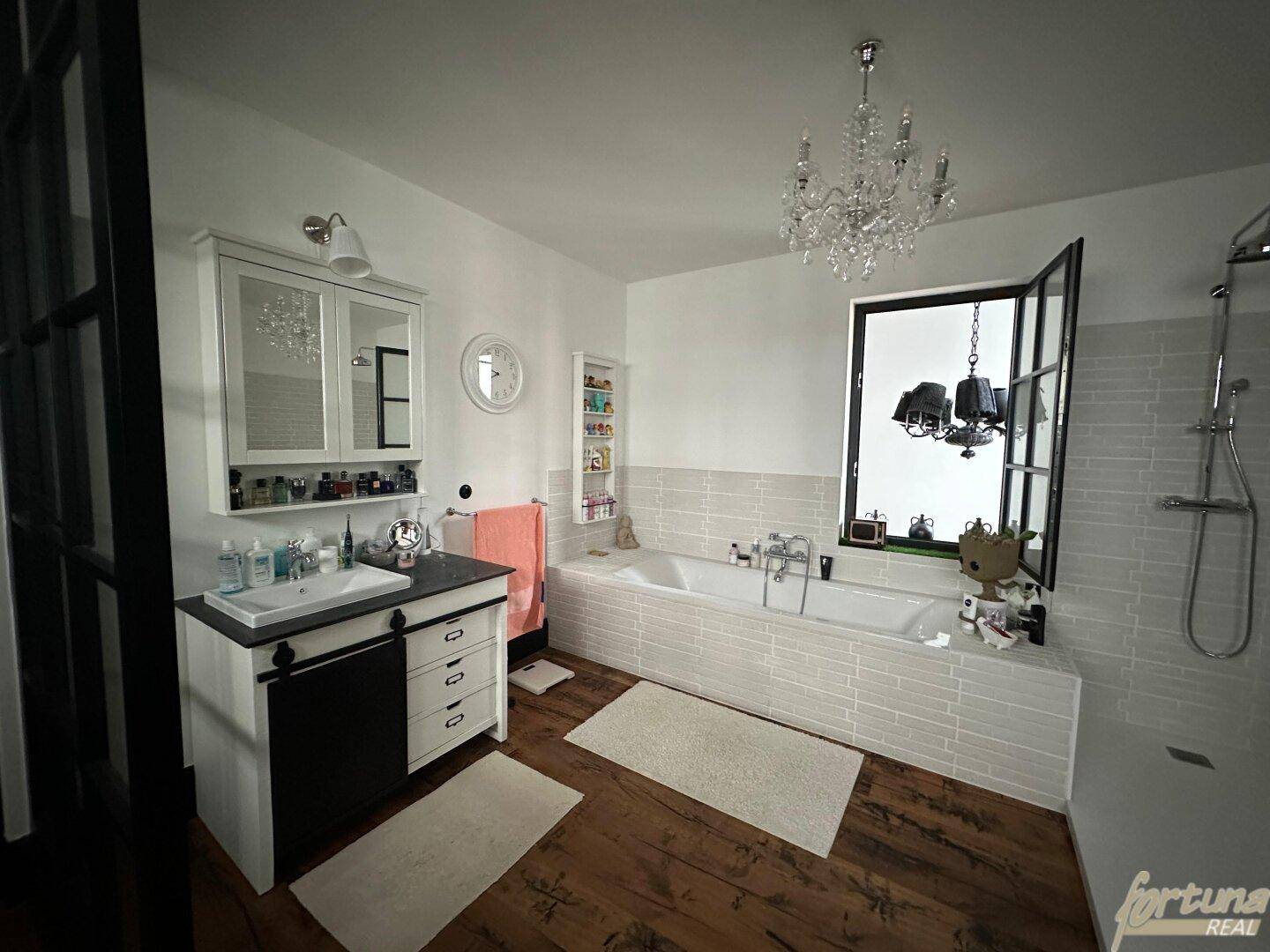 Modernes Badezimmer mit Badewanne, Einzelwaschbecken und einer geräumigen begehbaren Dusche.
