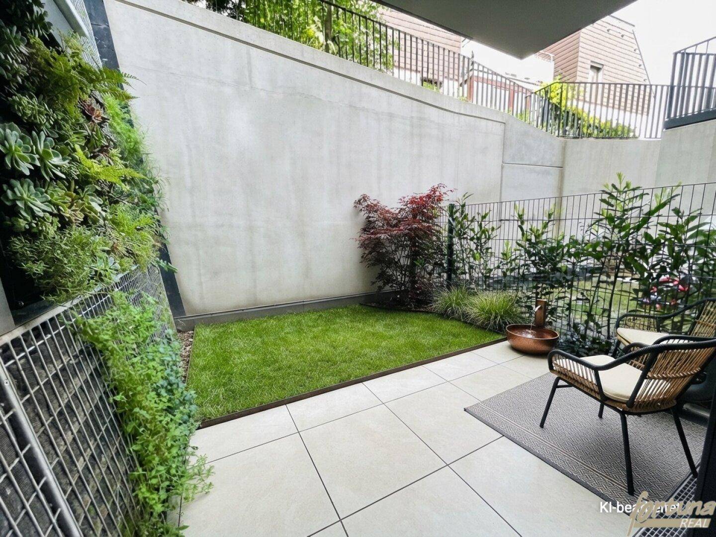Kleiner Gartenbereich mit Rasenfläche, vertikaler Bepflanzung und Sitzgelegenheiten.