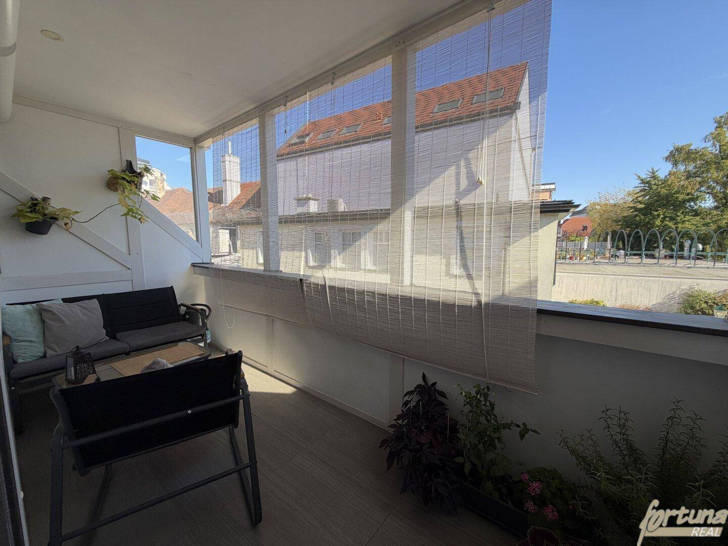 Überdachter Balkon mit Sitzgelegenheiten und Blick auf die Umgebung.