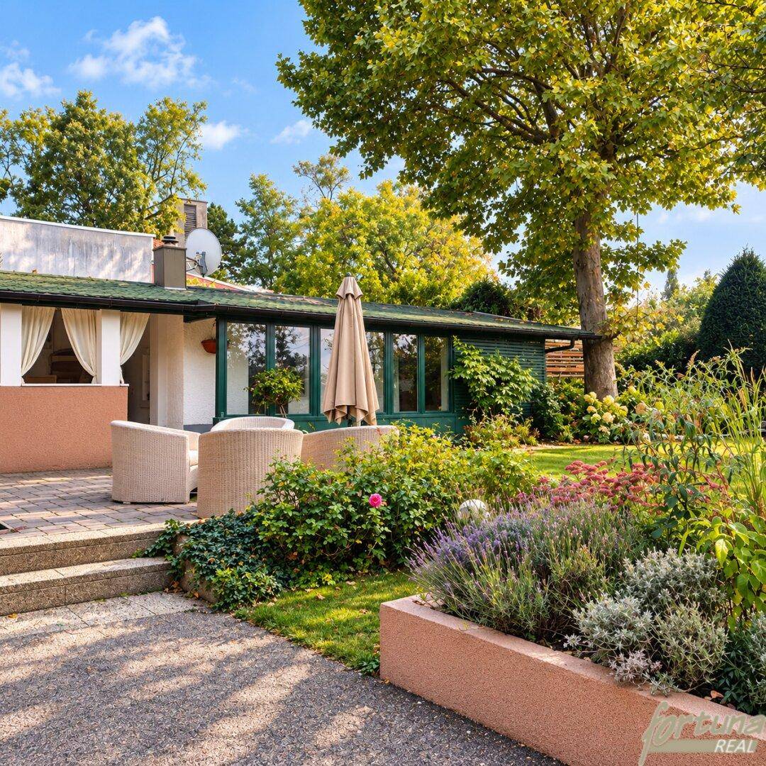 Gemütliche Terrasse mit Sitzgelegenheiten, umgeben von einem gepflegten Garten und Bäumen.