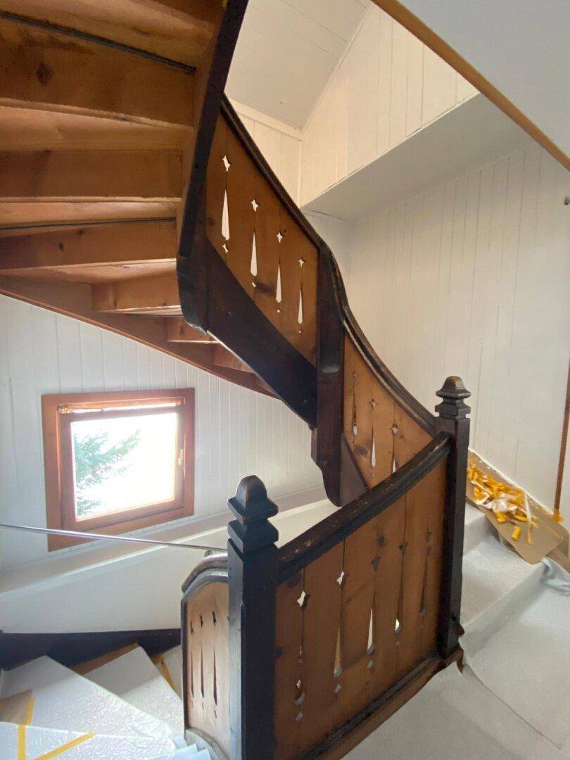 Traditionelle Holztreppe mit geschnitzten Details, die in die oberen Stockwerke führt.