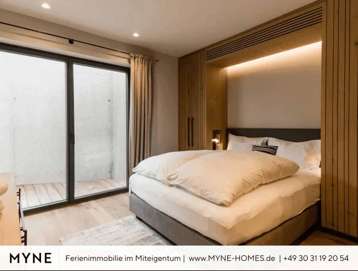 Gemütliches Schlafzimmer mit Holzelementen, großem Bett und Zugang zu einem privaten Außenbereich.