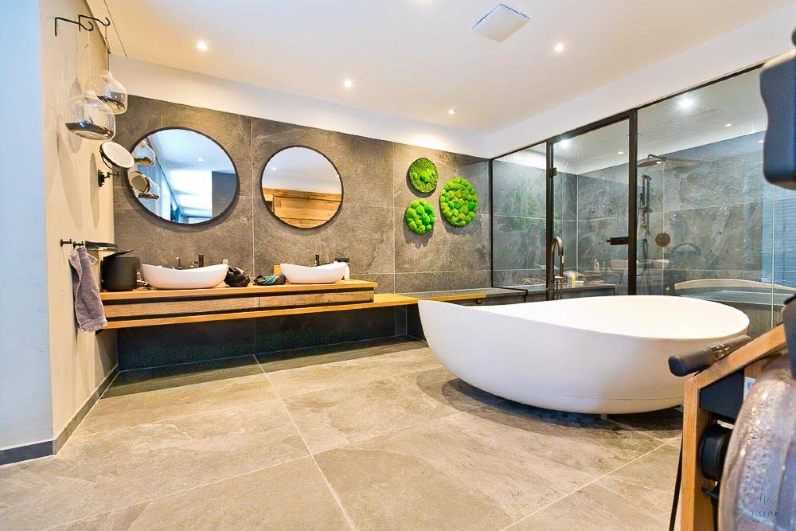 Luxuriöses Badezimmer mit freistehender Badewanne, Doppelwaschbecken und großer Duschkabine.