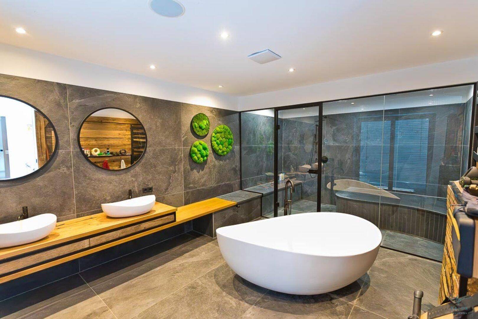 Elegantes Badezimmer mit moderner freistehender Wanne, Doppelwaschbecken und geräumiger Dusche.