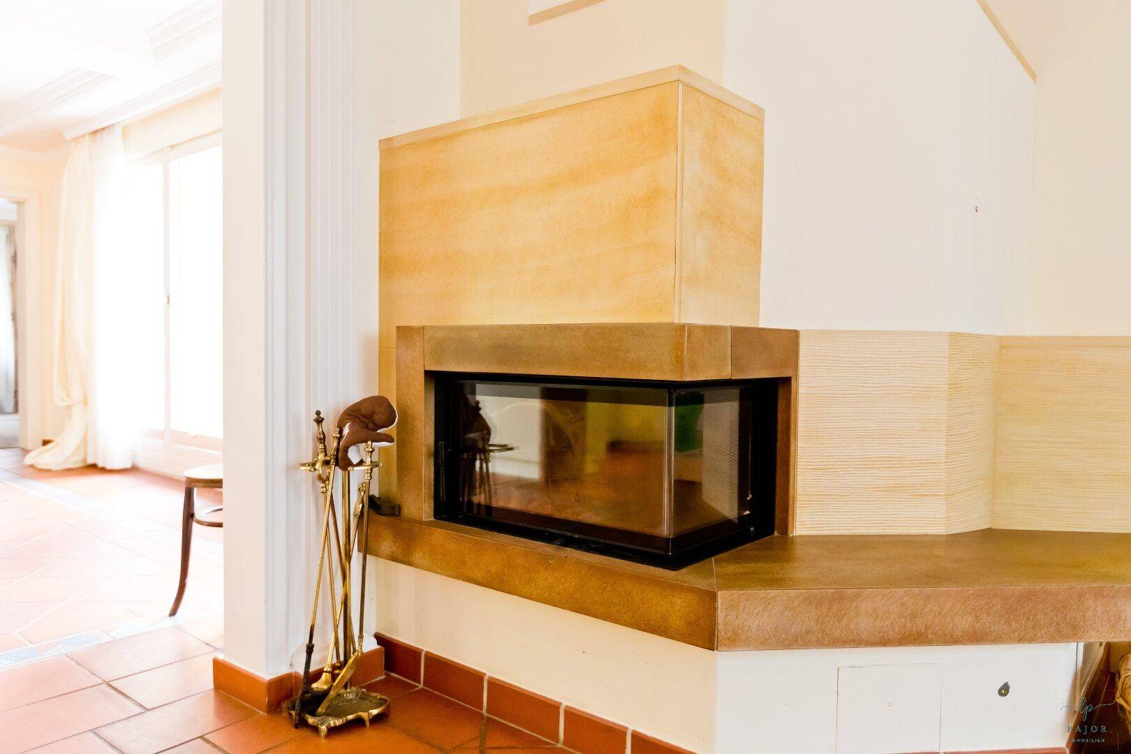 Moderner Kamin mit Glaseinsatz und Terrakottafliesen im Wohnbereich.