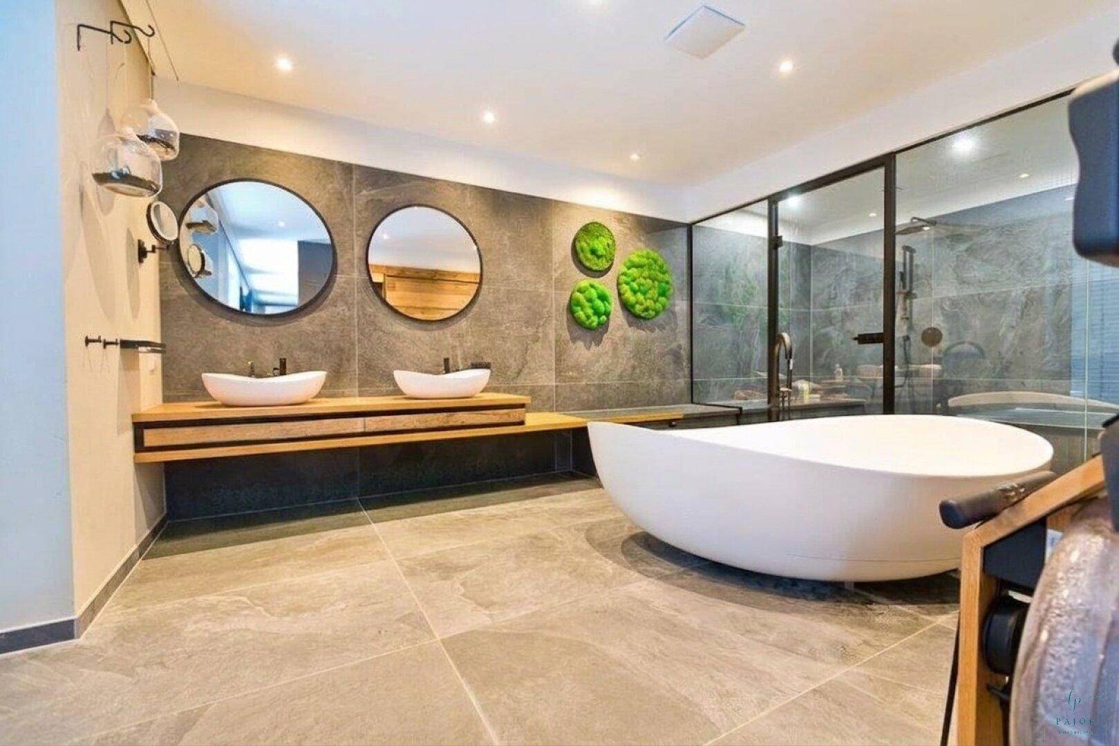 Modernes Badezimmer mit freistehender Badewanne, Doppelwaschbecken und großer Duschkabine.