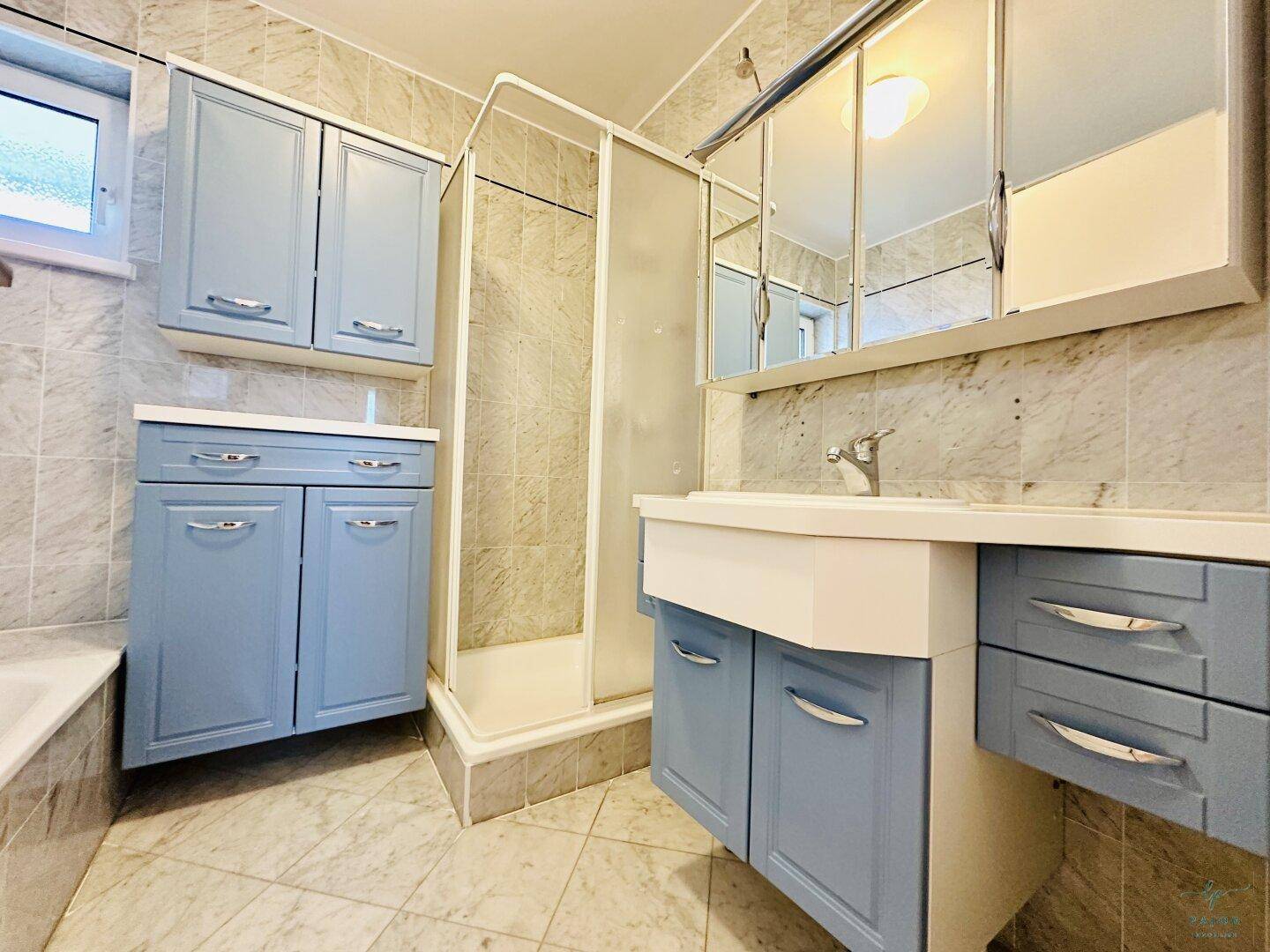 Badezimmer mit Badewanne, Dusche und Fenster