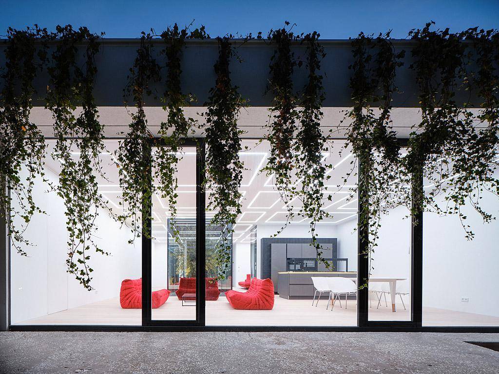 Offener Wohn- und Essbereich mit großen Glasfronten und Blick auf den Garten.