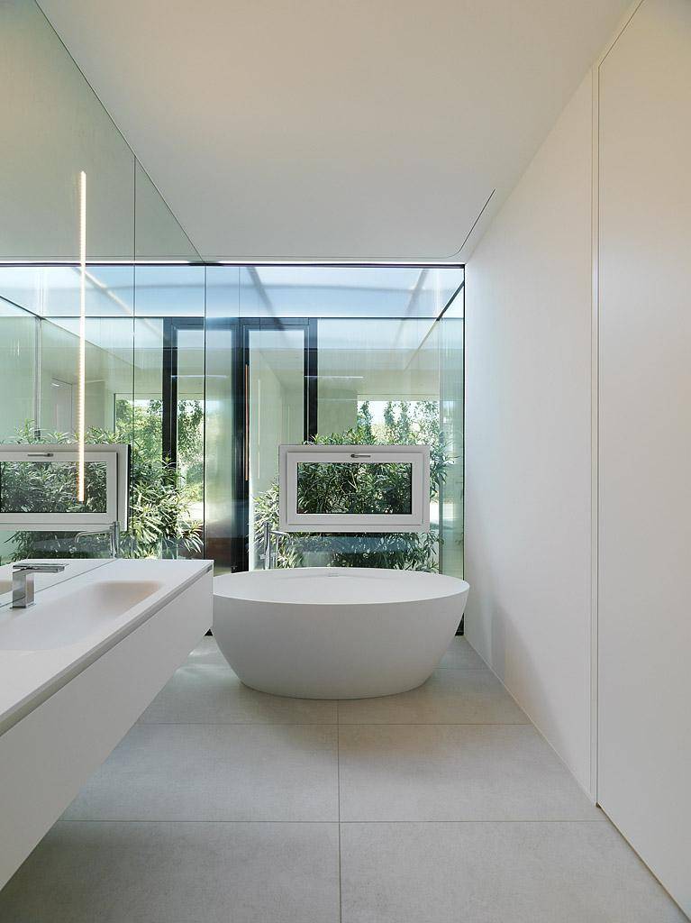 Elegantes Badezimmer mit freistehender Badewanne, minimalistischem Design und Blick ins Grüne.