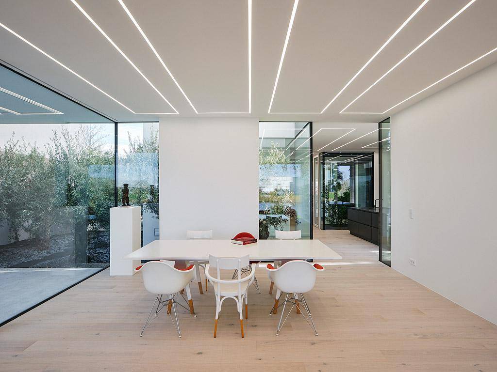 Geräumiger Essbereich mit modernem Tisch und Stühlen, Holzboden und viel Tageslicht durch große Fenster.