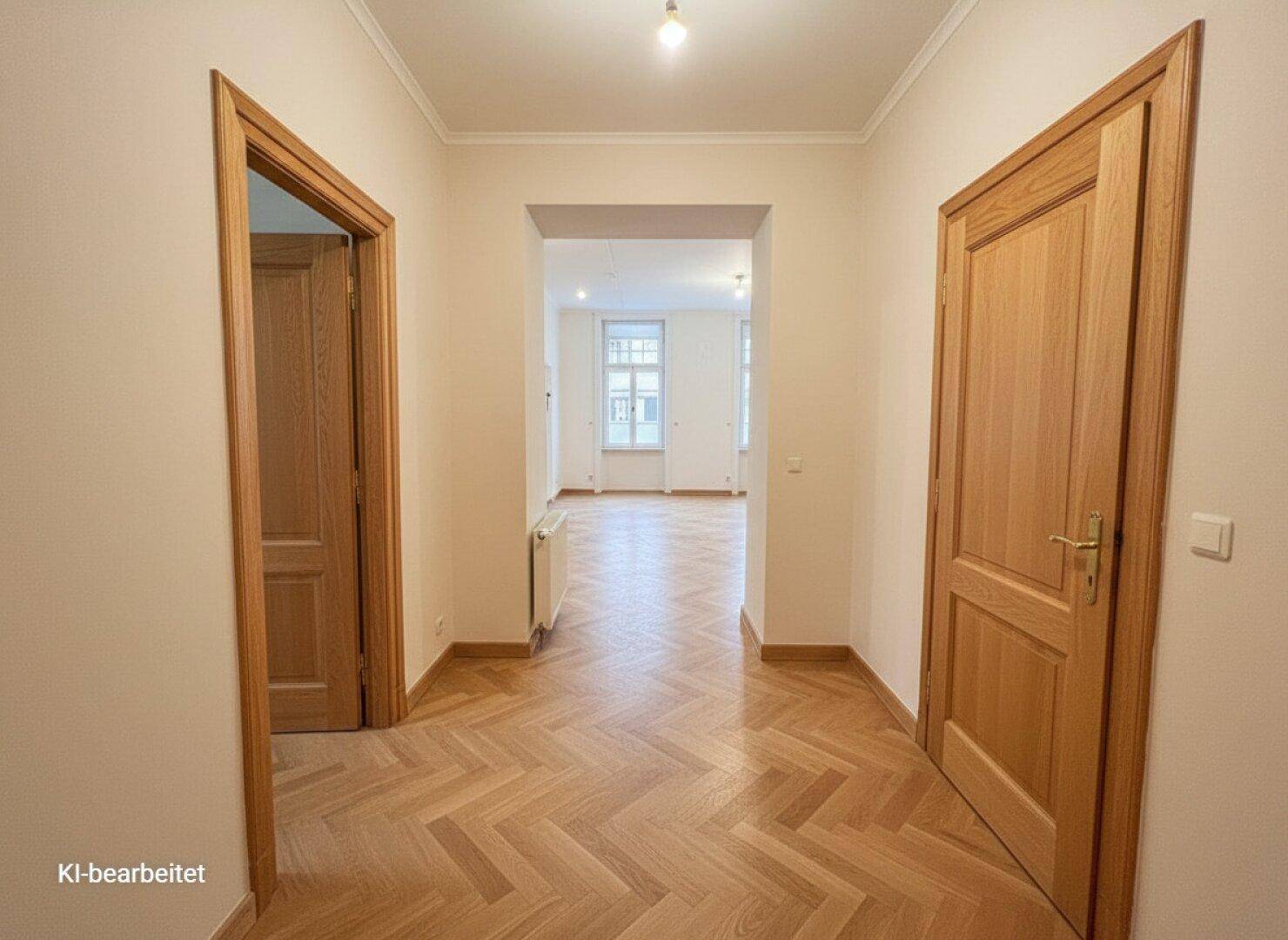 Heller Flur mit Fischgrätparkett und Holztüren, der zu weiteren Räumen führt.