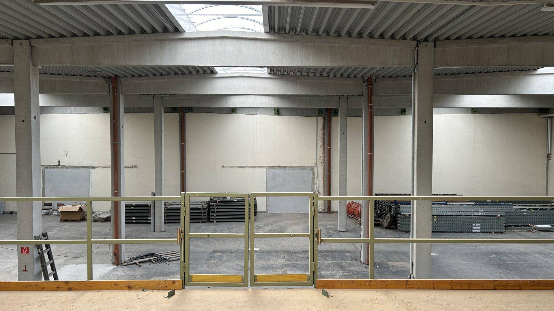Blick von der oberen Ebene einer Lagerhalle auf die darunterliegende Fläche mit Säulen.