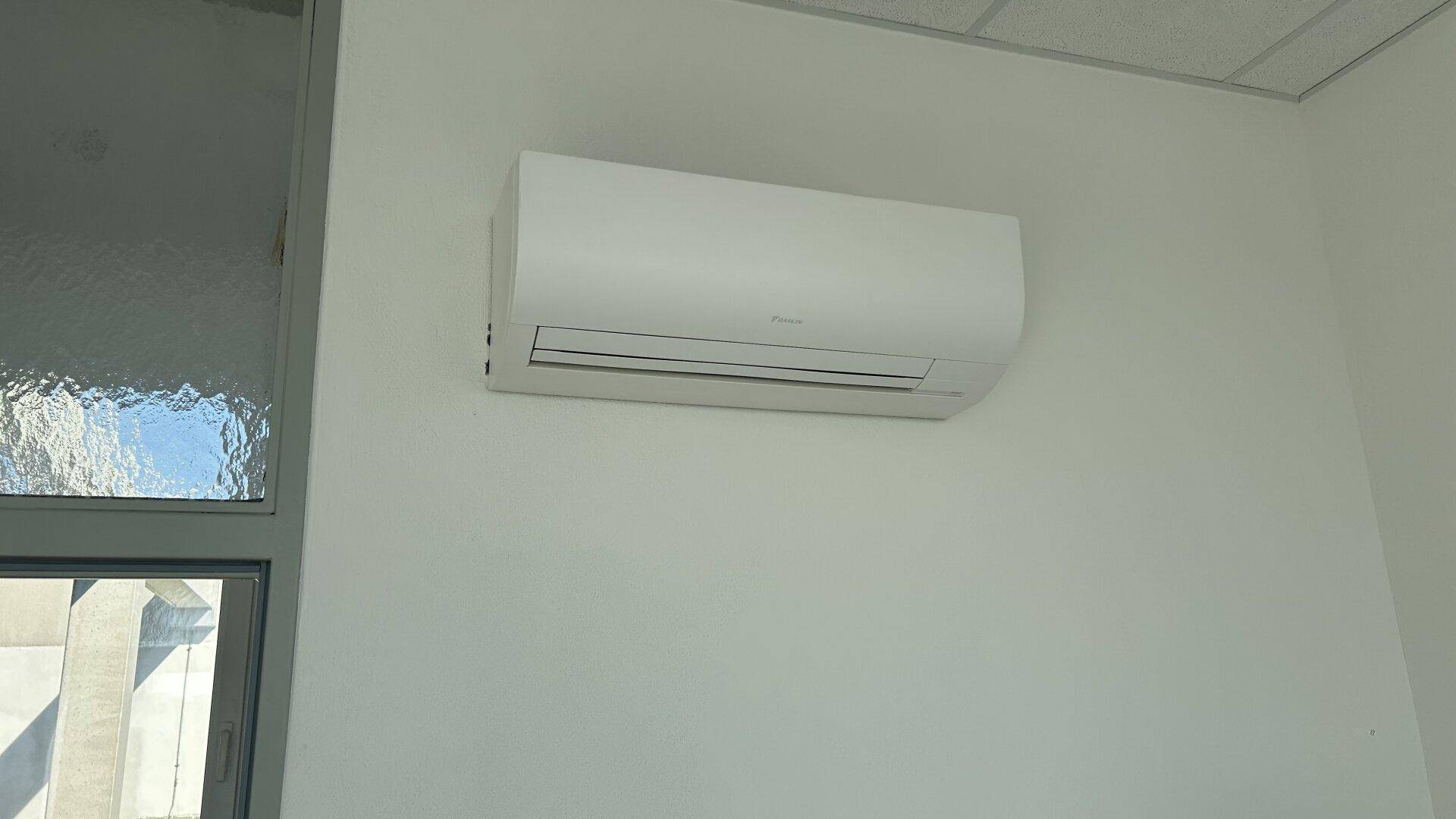 Eine moderne Klimaanlage ist an der weißen Wand montiert, sorgt für angenehme Raumtemperatur.