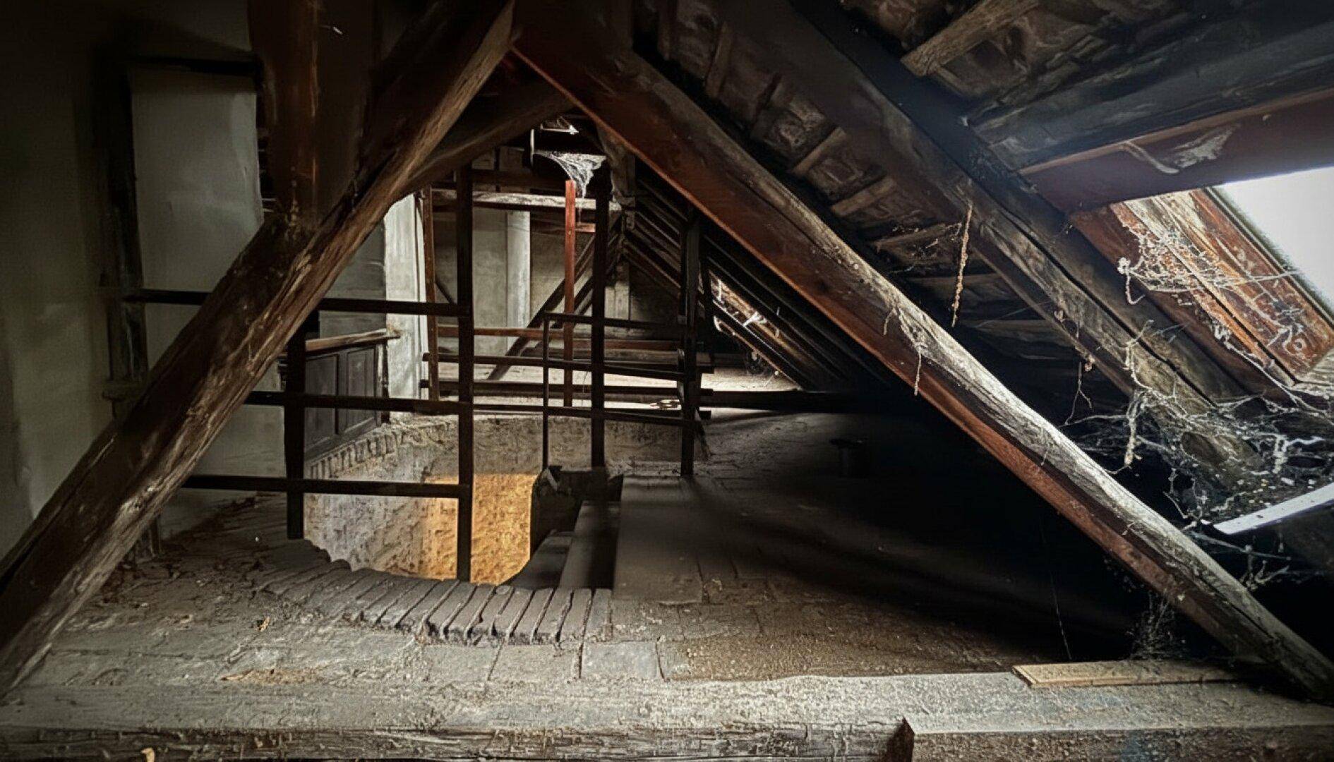 Dachboden mit komplexer Holzkonstruktion und Blick auf den unteren Bereich.