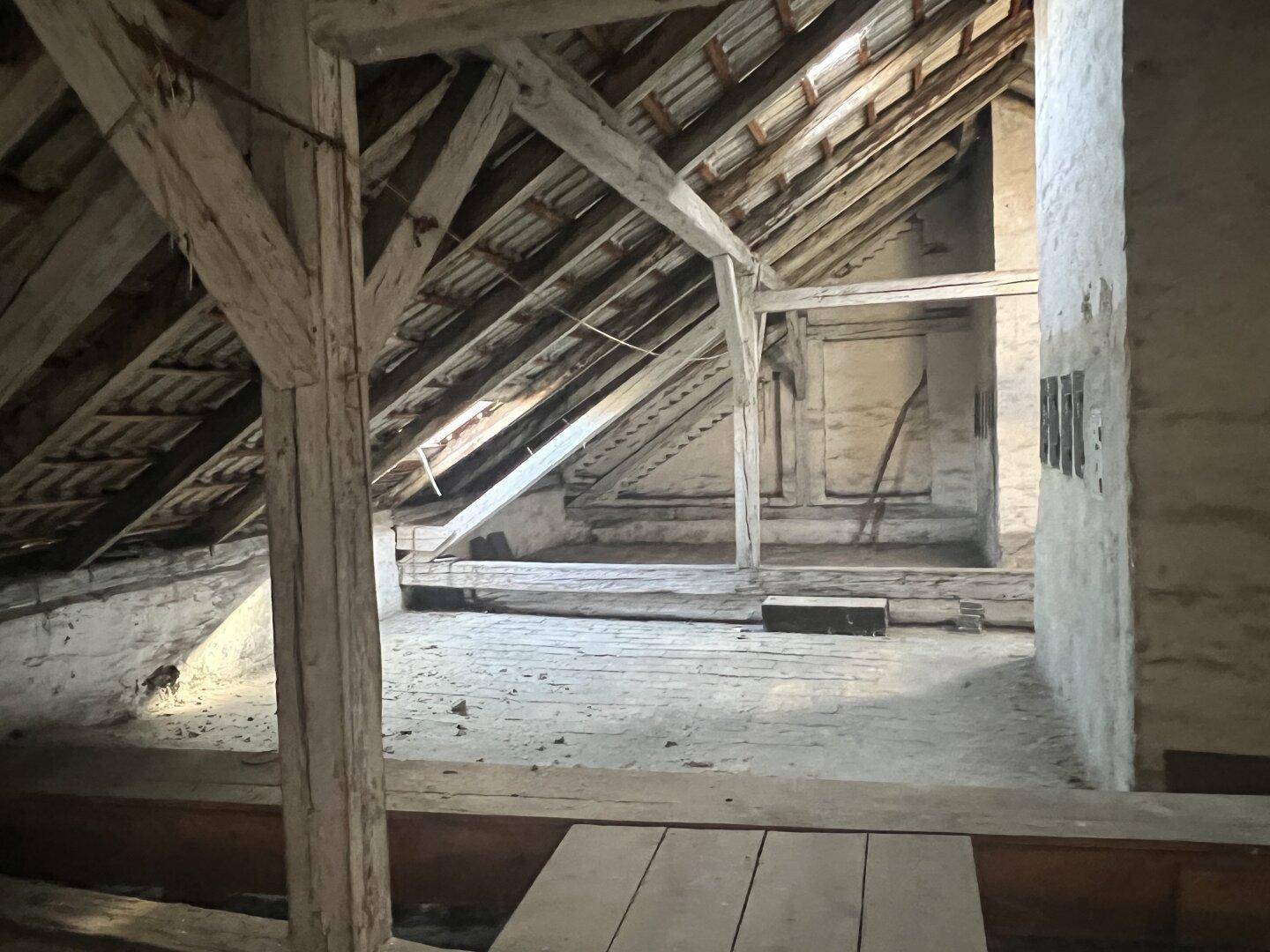 Geräumiger, unausgebauter Dachboden mit sichtbaren Holzbalken und viel Potenzial für Ausbau.
