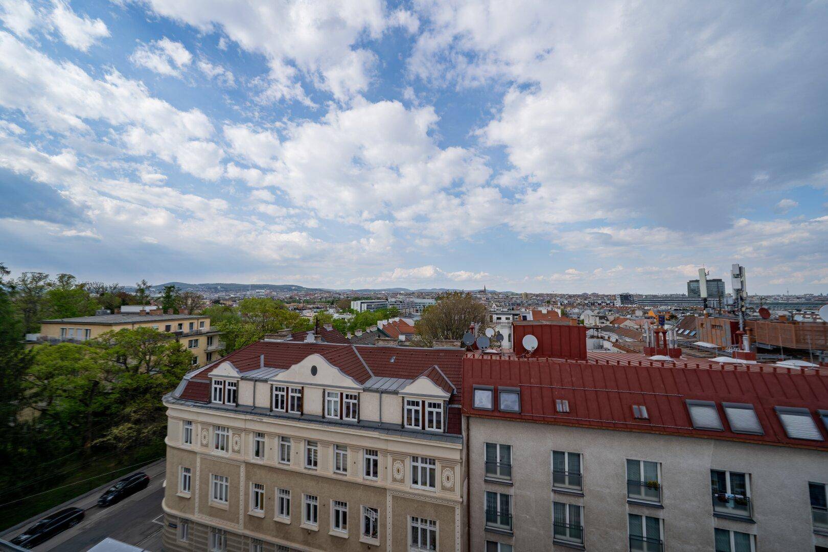 Panoramablick über ein städtisches Viertel mit verschiedenen Gebäuden und viel Grün.