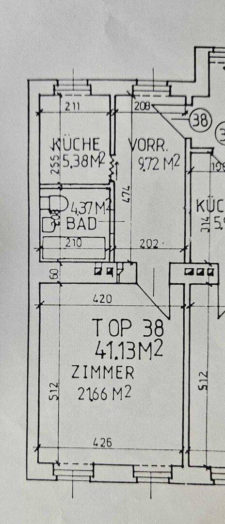 Grundriss zeigt die Aufteilung einer Wohnung mit Küche, Bad und Zimmern.
