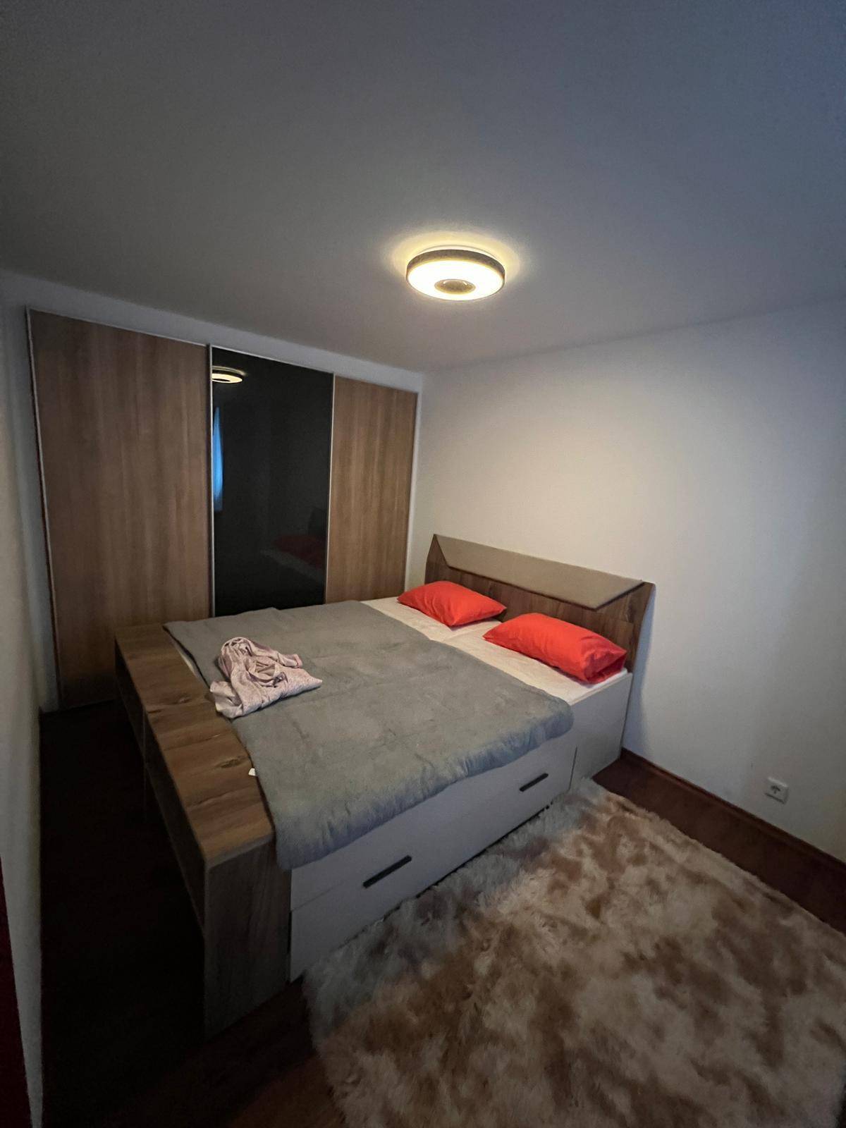 Gemütliches Schlafzimmer mit Doppelbett, Teppich und großem Kleiderschrank.