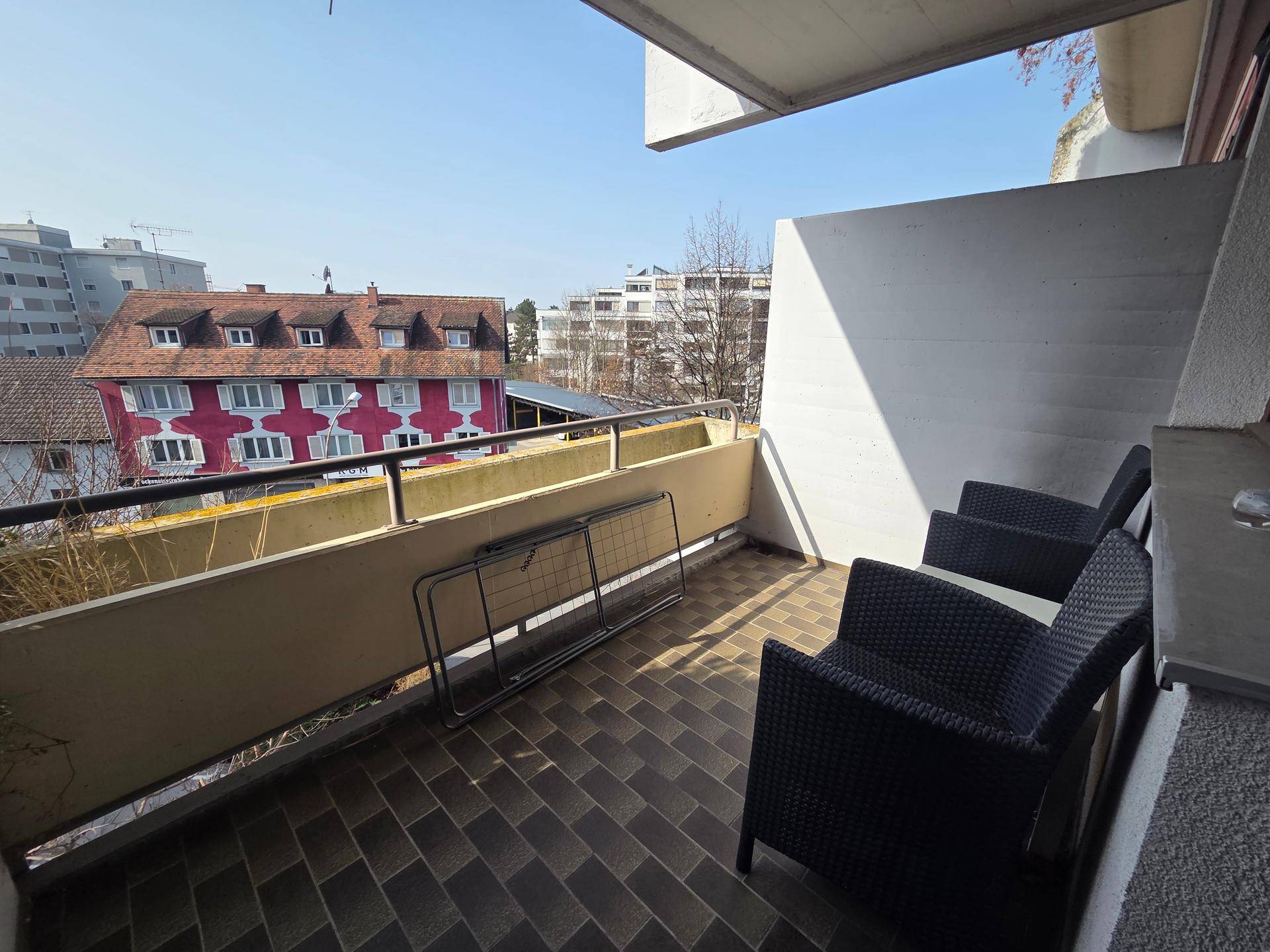 Geräumiger Balkon mit Fliesenboden und Sitzgelegenheiten, bietet Blick auf die Umgebung.