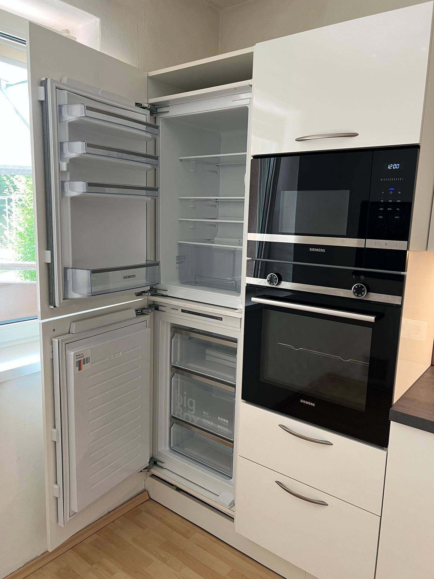 Integrierter Kühlschrank und Gefrierschrank in einer modernen Küche mit Siemens-Geräten.