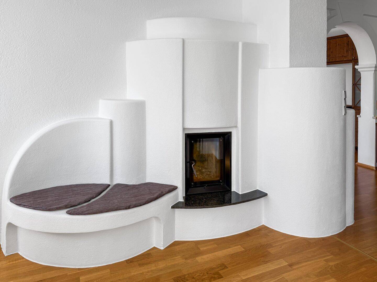 Moderner Kaminofen mit integrierter Sitzbank im hellen Wohnzimmer.