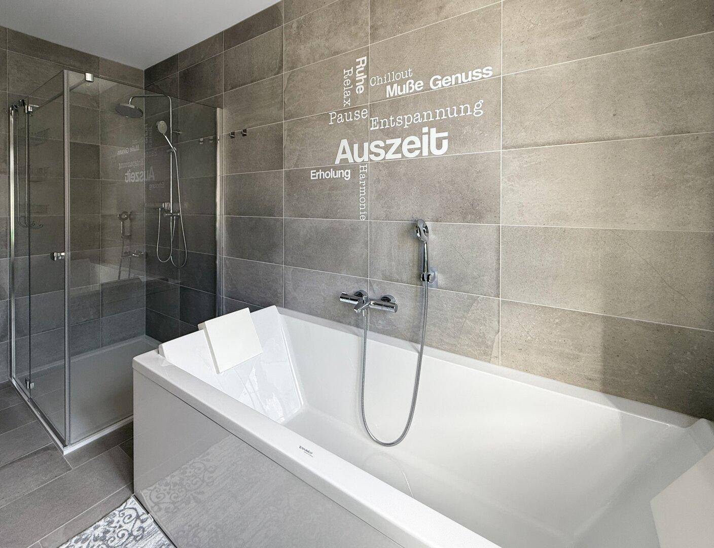 Modernes Badezimmer mit Badewanne und separater Glasdusche.