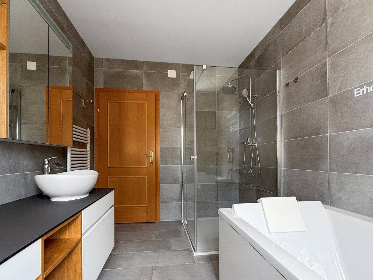 Modernes Badezimmer mit Dusche, Badewanne und Waschtisch.