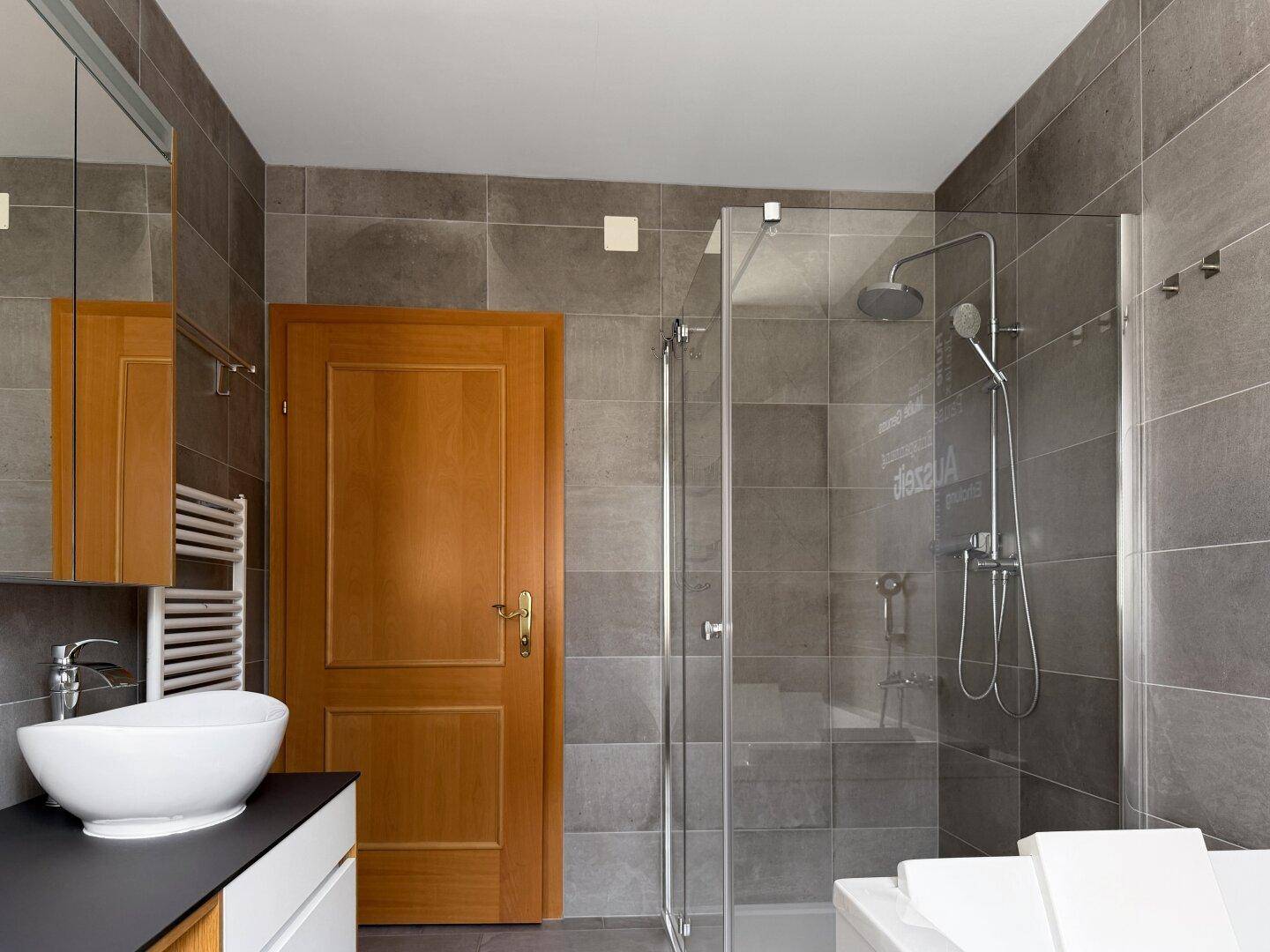Modernes Badezimmer mit Dusche, Badewanne und Waschtisch.