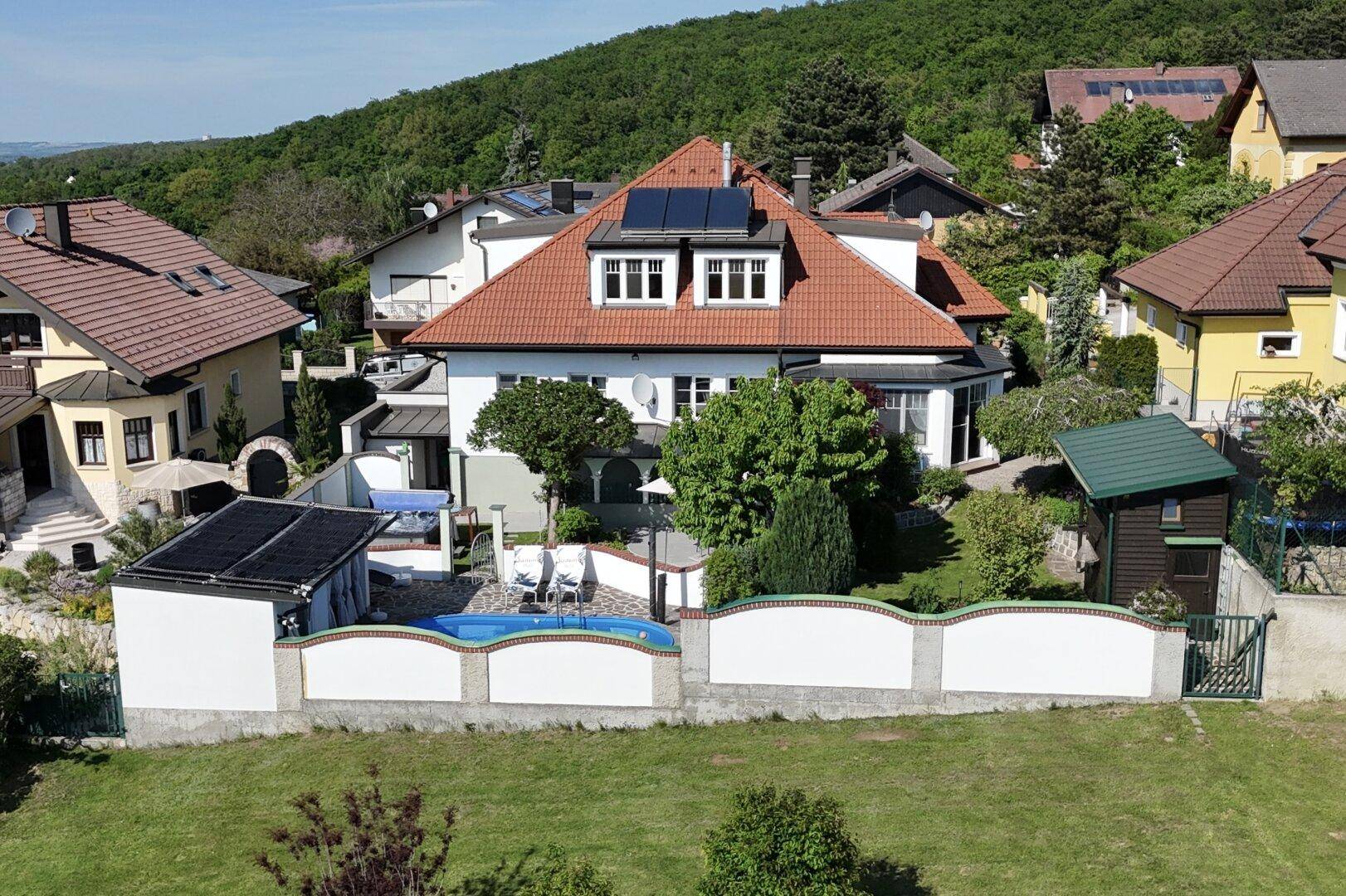 Weitläufiges Anwesen mit Haus, Garten, Pool und Photovoltaikanlage auf dem Dach.