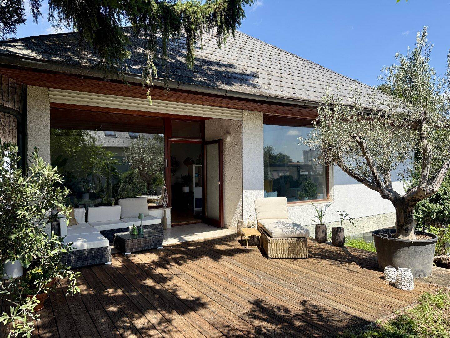Geräumige Holzterrasse mit bequemen Outdoor-Möbeln und direktem Zugang zum Haus.