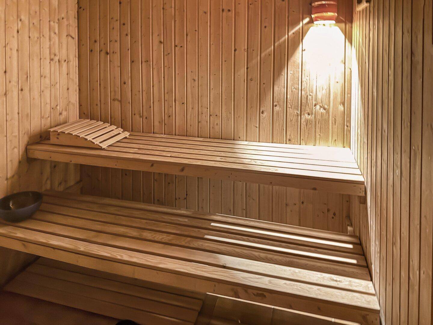 Private Sauna mit Holzverkleidung und Sitzbänken für Entspannung.