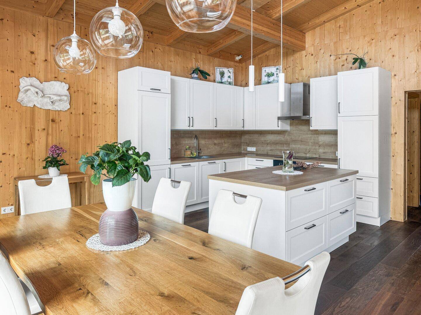 Offener Wohn-Essbereich mit moderner Küche, großem Holztisch und gemütlicher Atmosphäre, ideal für Familien.