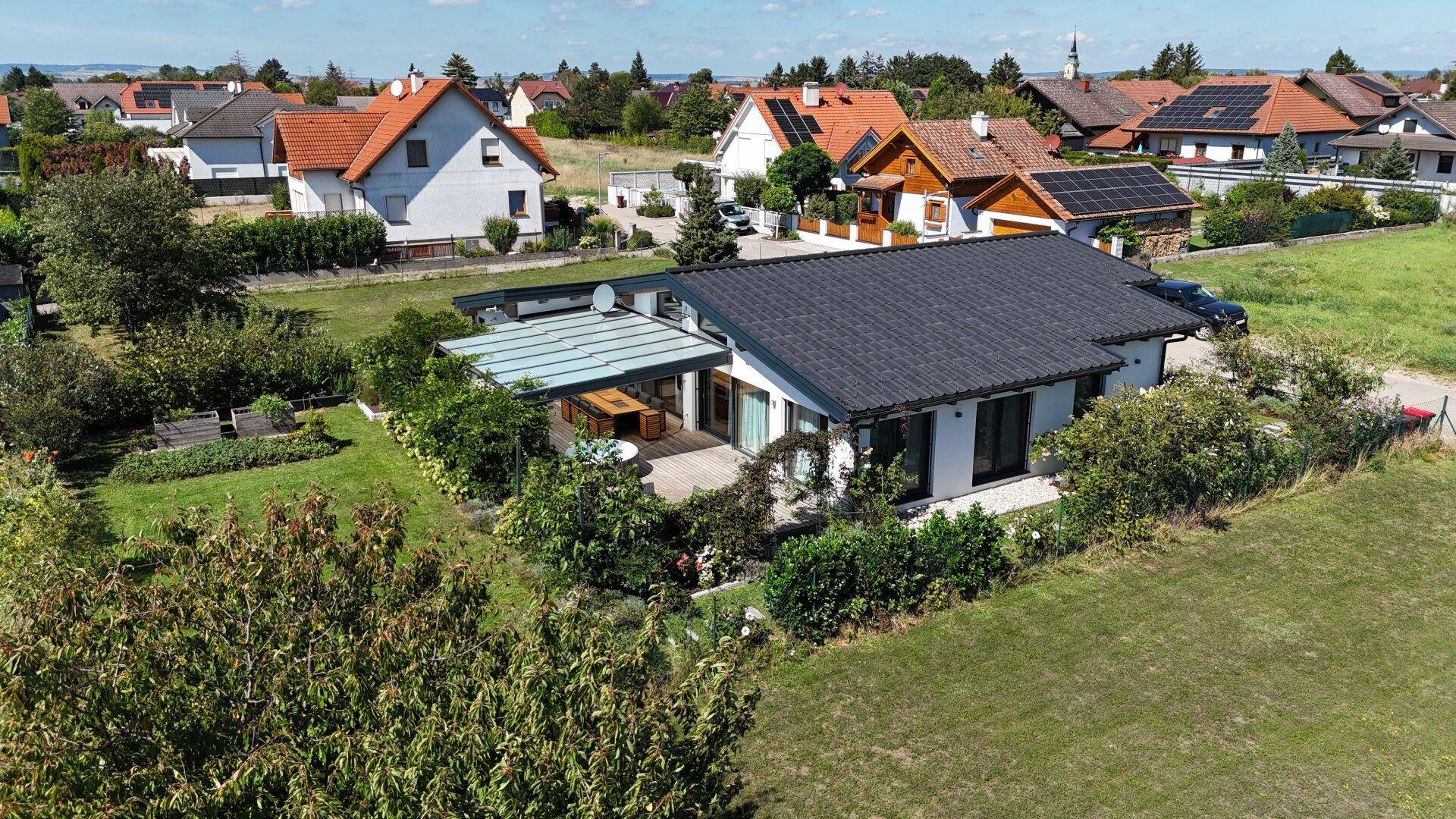 Luftaufnahme des Hauses mit großem Garten und der umliegenden Wohnsiedlung.