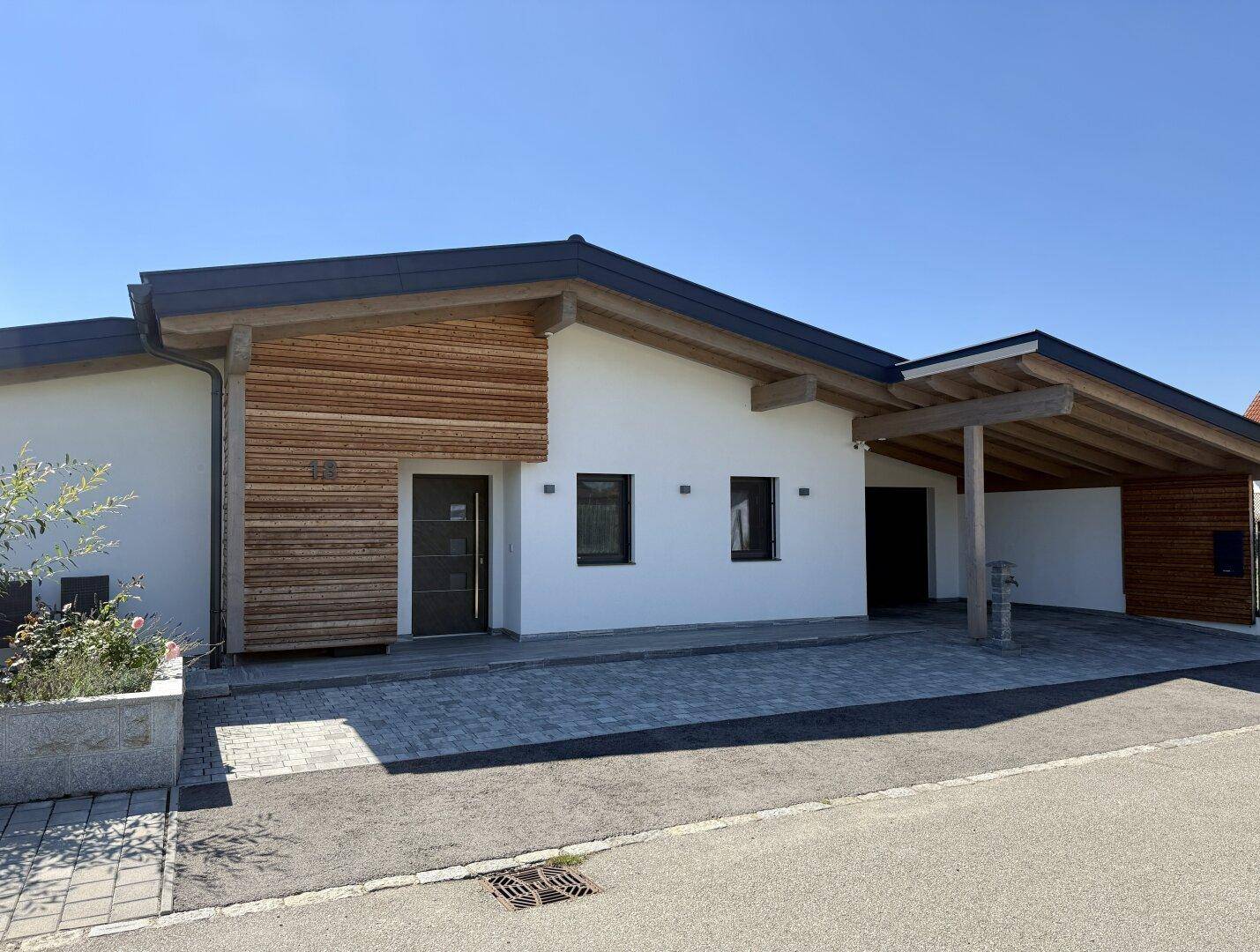 Gesamtansicht des modernen Einfamilienhauses mit Carport und ansprechender Architektur.
