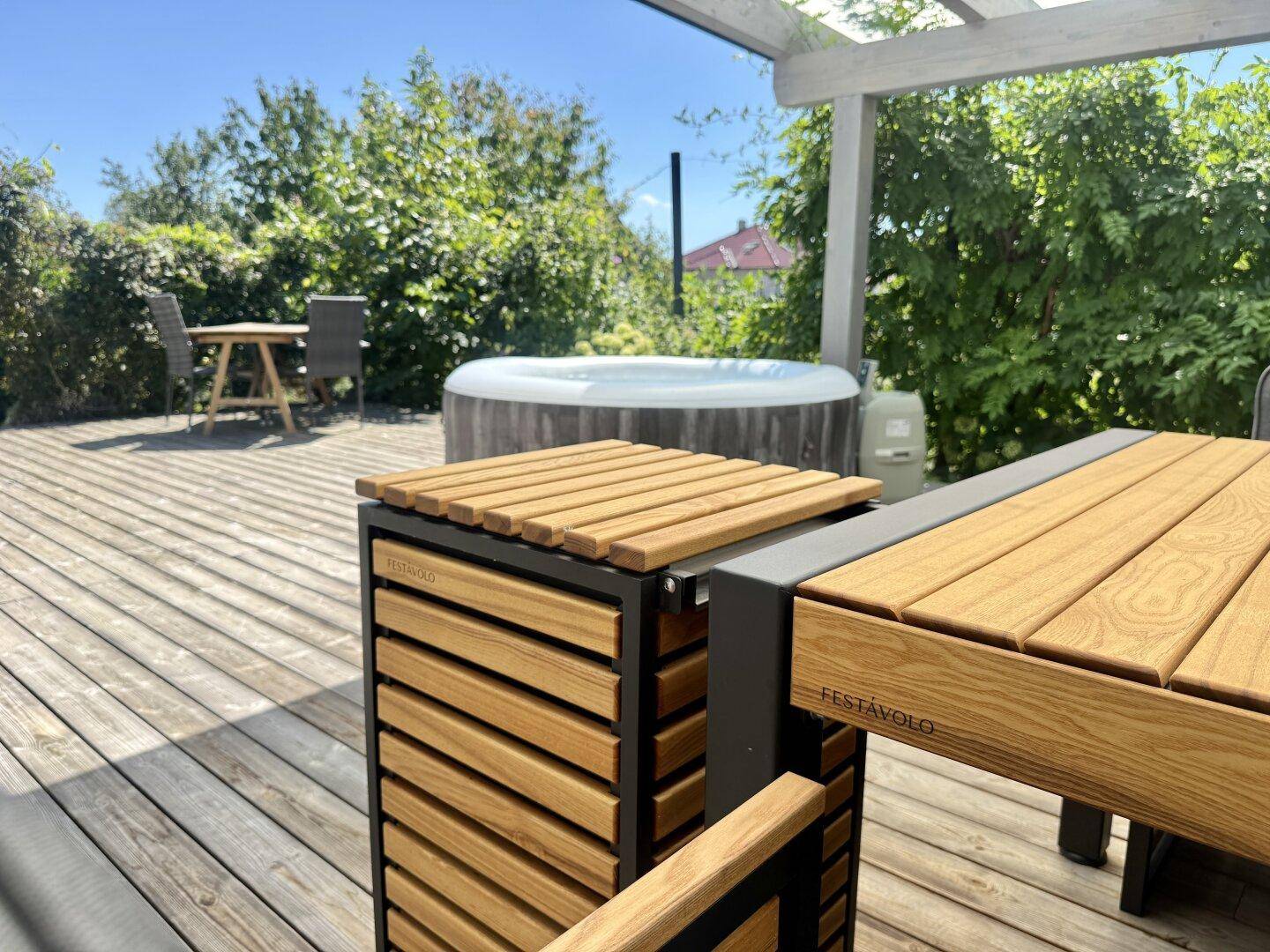 Moderner Esstisch mit Holzlamellen und integriertem Grill auf der Holzterrasse.