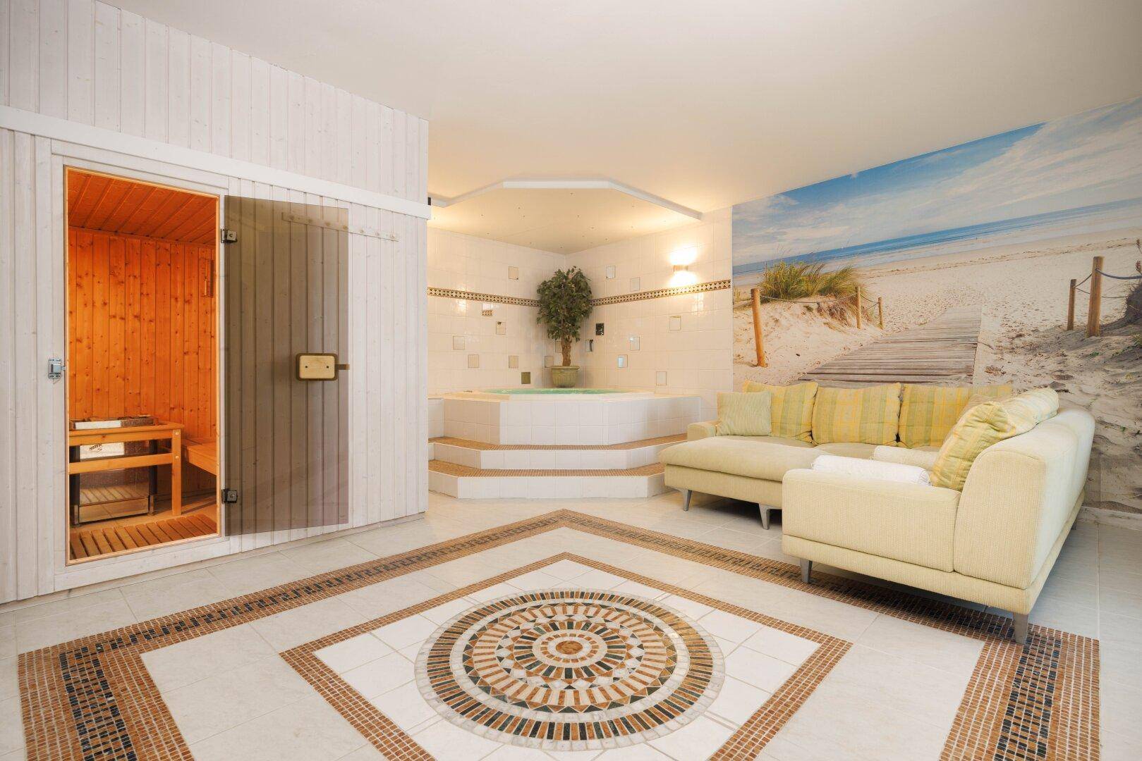 Entspannender Wellnessbereich mit Sauna, Whirlpool und Strandmotiv-Wandbild.