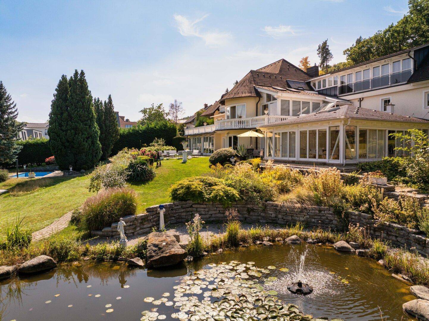 Großzügige Villa mit weitläufigem Garten, Teich mit Springbrunnen und sonnigen Terrassen.