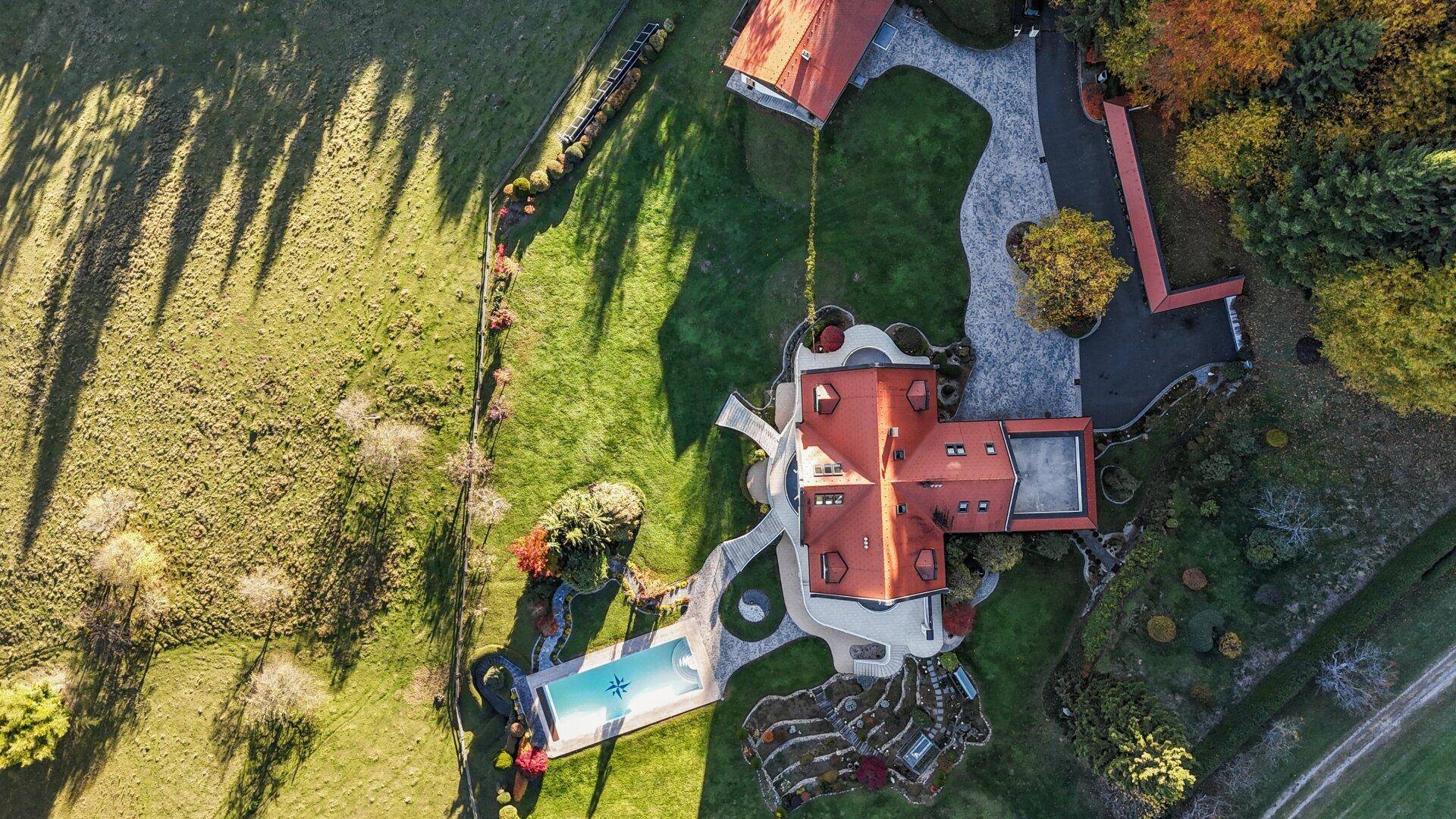 Vogelperspektive des Anwesens mit Villa, Pool und weitläufiger Gartenanlage.