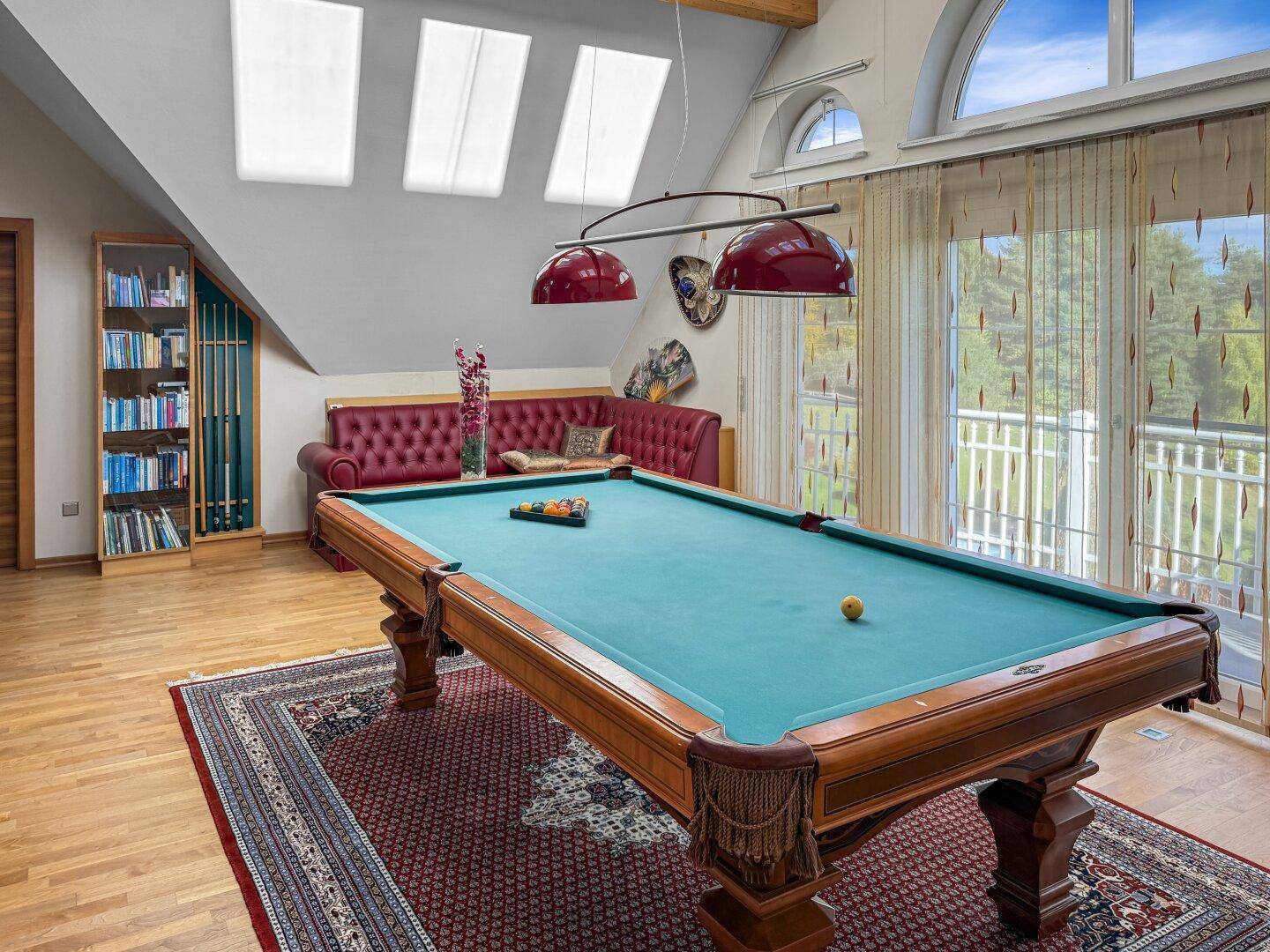 Spielzimmer mit Billardtisch, Dachfenstern und Zugang zum Balkon.