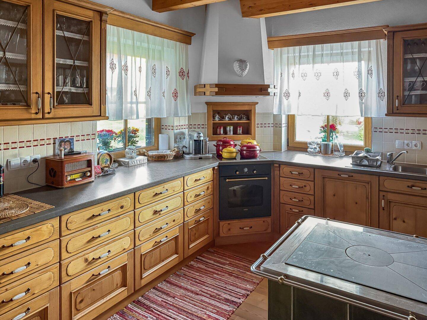Gemütliche traditionelle Küche mit Holzschränken, Backofen und gefliestem Spritzschutz.