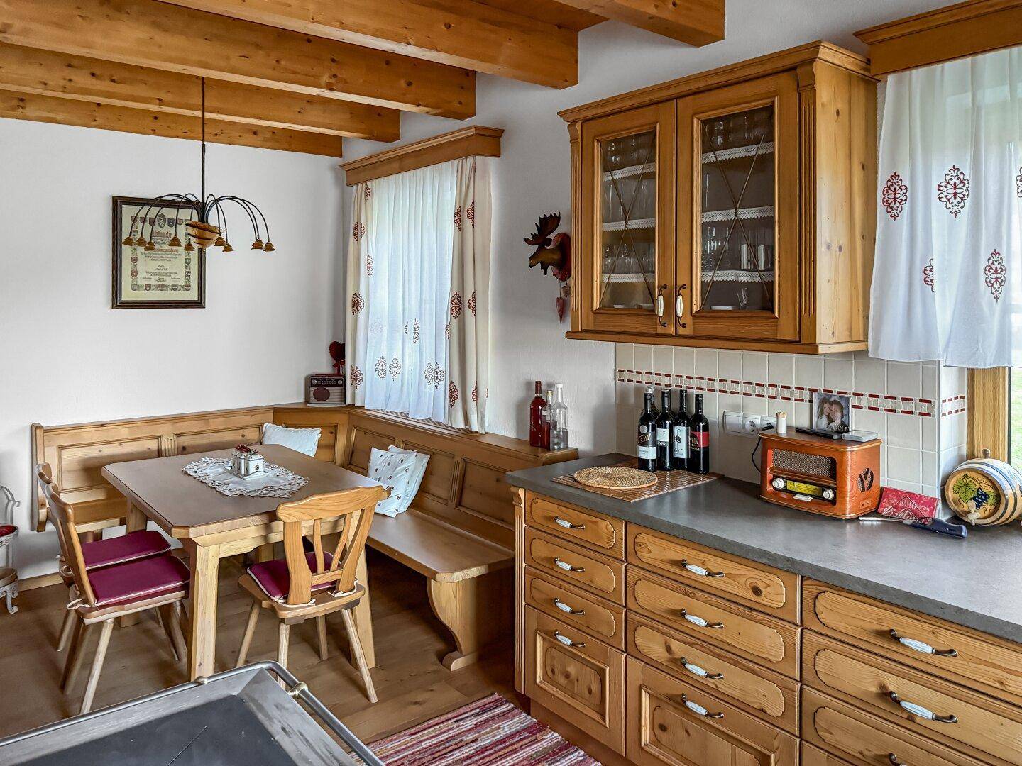 Traditionelle Wohnküche mit Holzbalken, Eckbank und rustikalen Holzmöbeln.