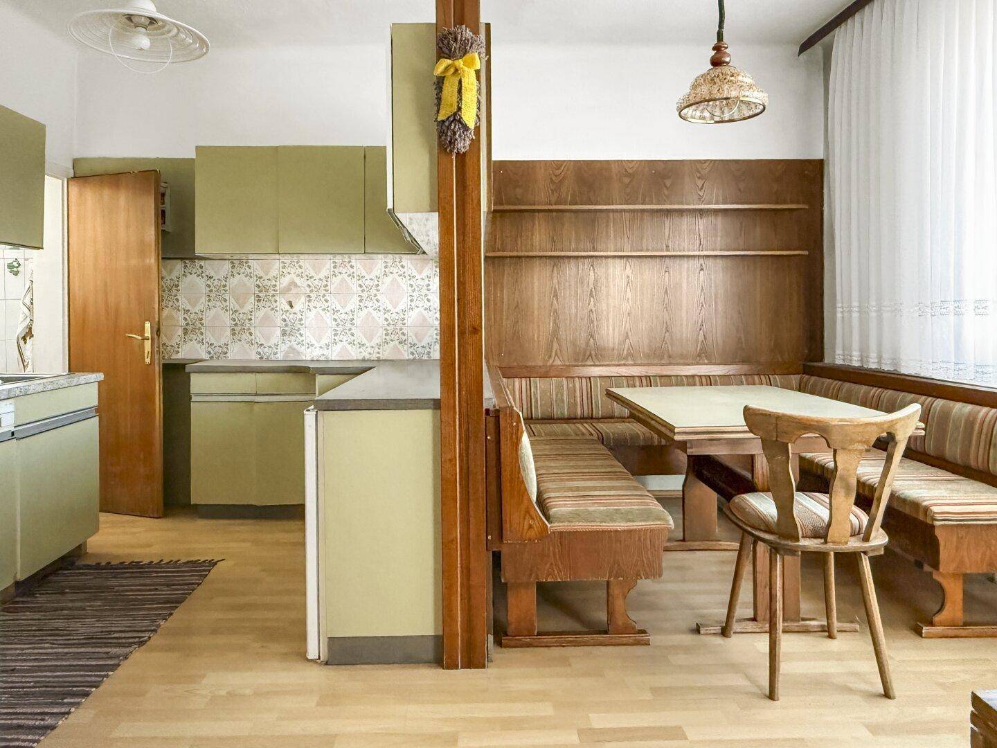 Gemütliche Küche mit Essbereich, Holzvertäfelung und traditionellen Möbeln, die zum Verweilen einlädt.